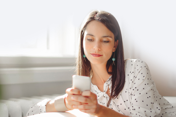 woman using Zelle on her phone